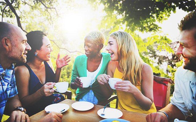 Photo of diverse group of adult enjoying coffee outside