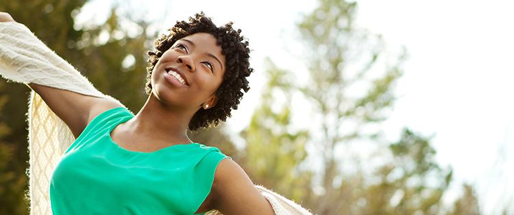 Photo of a smiling black woman with arms open wide