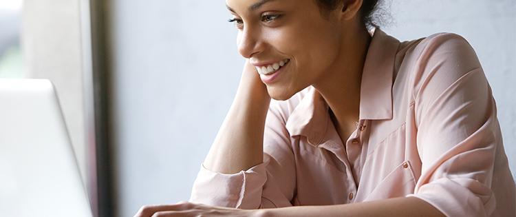 Photo of a 20-something woman looking at a laptop