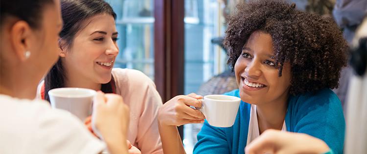 Photo of a diverse group of women talking while drinking coffee
