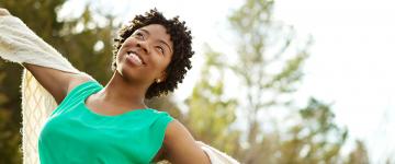 Photo of a smiling black woman with arms open wide
