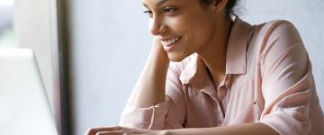 Photo of a 20-something woman looking at a laptop