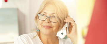 Photo of a older Latina woman holding a phone near her face