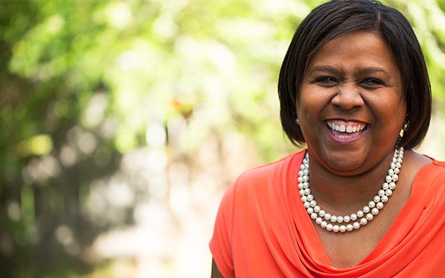 Photo of a middle aged black woman smiling outside