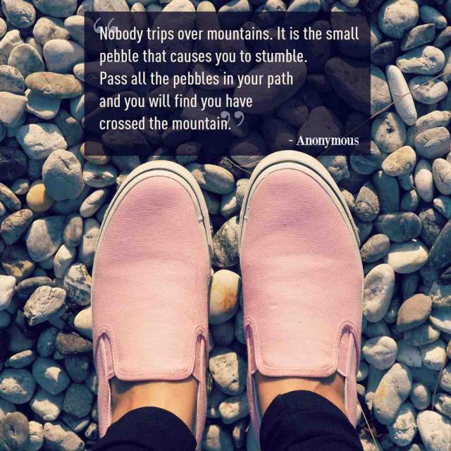 Photo of pink shoes on pebbles with text saying "Nobody trips over mountains. It is the small pebble that causes you to stumble. Pass all the pebbles in your path  and you will find you have crossed the mountain."