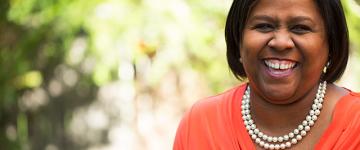 Photo of a middle aged black woman smiling outside